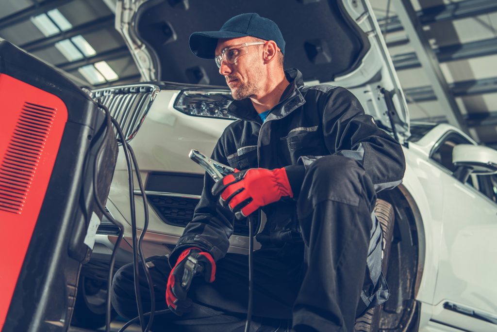 Car Battery Jump Starter Auto Service Worker Preparing Car Battery Jump Starter.